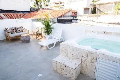 a patio with a jacuzzi tub on a building at Casa Quero 915 4BR House Old City rooftop jacuzzi AC full Wifi in Cartagena de Indias