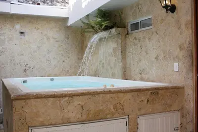a bathroom with a tub with a waterfall at Casa Moneda 1 5BR amazing house picusi AC old city in Cartagena de Indias