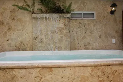 a bath tub with a water fountain in a bathroom at Casa Moneda 1 5BR amazing house picusi AC old city in Cartagena de Indias
