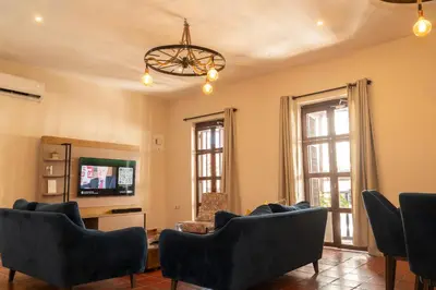 a living room with couches and a tv and windows at Casa Quero 954 COZY HOUSE ROOFTOP POOL AC OLD CITY in Cartagena de Indias