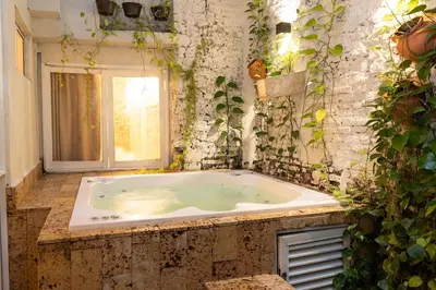 a jacuzzi tub in a room with plants at Casa Quero 914, 3br Old city wifi jacuzzi in Cartagena de Indias