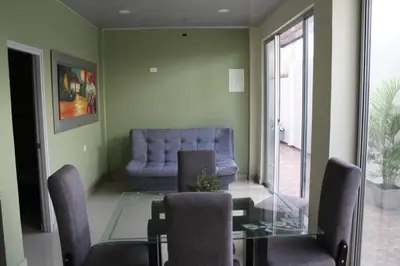 a dining room with a glass table and a blue couch at APARTAMENTOS AMOBLADOS in Santa Marta