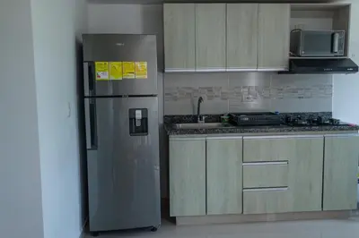 a kitchen with a stainless steel refrigerator and cabinets at Apartasol Amoblado Primer Piso Coveñas in Coveñas