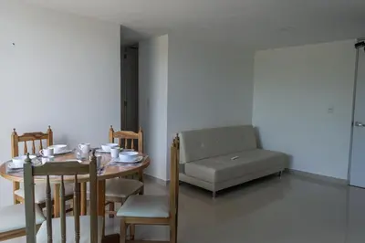 a dining room with a table and a couch at Apartasol Amoblado Primer Piso Coveñas in Coveñas