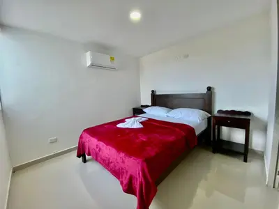 a bedroom with a bed with a red blanket at Apartasol Amoblado Primer Piso Coveñas in Coveñas