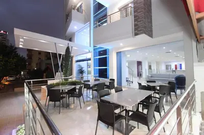 a restaurant with tables and chairs on a balcony at Hotel Oxford Barranquilla in Barranquilla