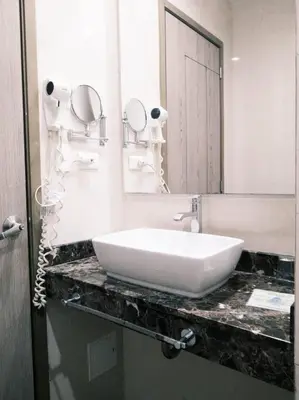 a bathroom with a white sink and a mirror at Hotel Oxford Barranquilla in Barranquilla