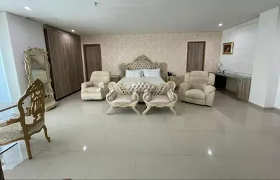 a bedroom with a bed and two chairs and a table at Hotel Oxford Barranquilla in Barranquilla
