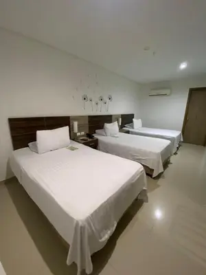 two beds in a hotel room with white sheets at Hotel Oxford Barranquilla in Barranquilla