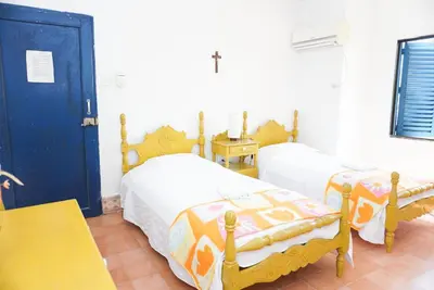 a bedroom with two beds and a blue door at Casa Antigua in San Silvestre