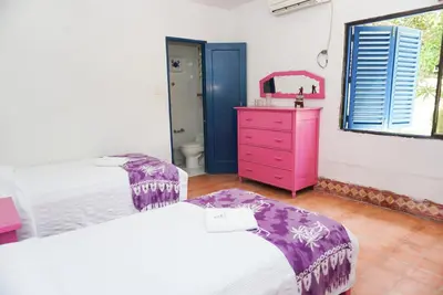 a bedroom with two beds and a pink dresser at Casa Antigua in San Silvestre