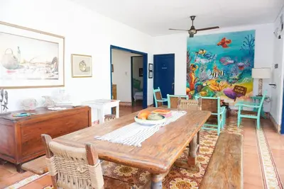 a living room with a table and a fish mural at Casa Antigua in San Silvestre