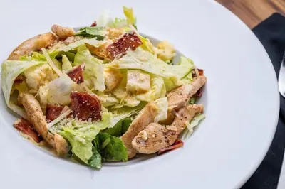 a white plate with a salad with chicken and lettuce at Oz Hotel Cartagena in Cartagena de Indias