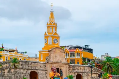 a church with a tower with a clock on it at Hotel Kartaxa in Cartagena de Indias