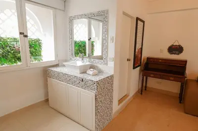 a bathroom with a sink and a mirror and a piano at Hotel Kartaxa in Cartagena de Indias