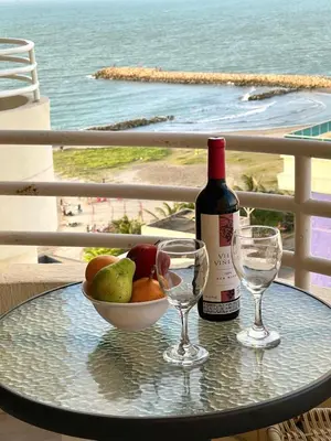 a table with a bottle of wine and two glasses at Cabrero Beach 1111 in Cartagena de Indias