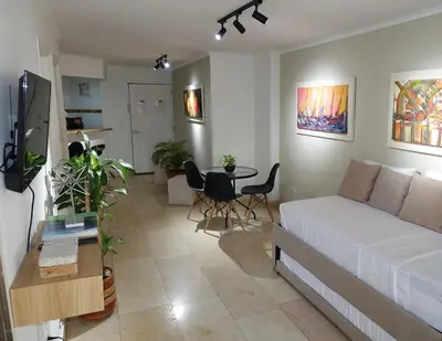 a living room with a white bed and a table at Cabrero Beach 1111 in Cartagena de Indias