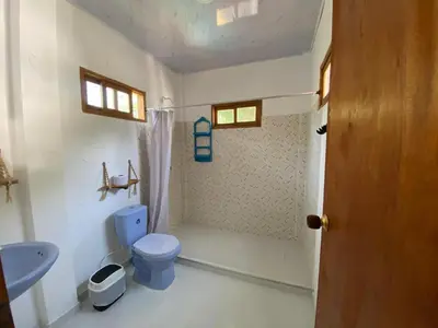 a bathroom with a blue toilet and a sink at CABAÑA ACUARIO in El Porvenir