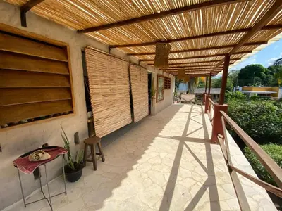 a wooden pergola on the side of a house at CABAÑA ACUARIO in El Porvenir