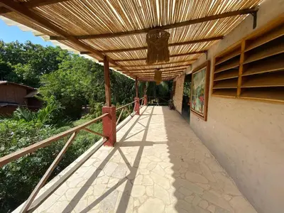 a wooden pergola on the side of a building at CABAÑA ACUARIO in El Porvenir