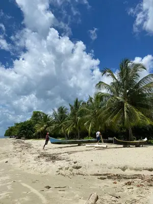 two people standing on a beach with two boats at CABAÑA ACUARIO in El Porvenir