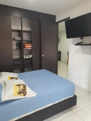 a room with a bed with a television and a refrigerator at Apartaestudio Cartagena 2P in Cartagena de Indias