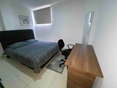 a bedroom with a bed and a wooden table at Lindo Apartamento vacacional in Cartagena de Indias