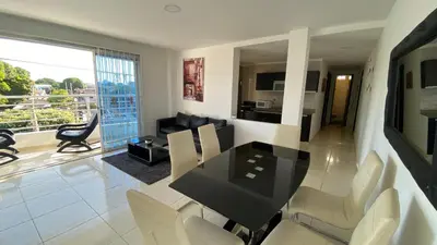 a dining room and living room with a table and chairs at Lindo Apartamento vacacional in Cartagena de Indias