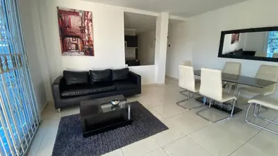 a living room with a black couch and a table at Lindo Apartamento vacacional in Cartagena de Indias