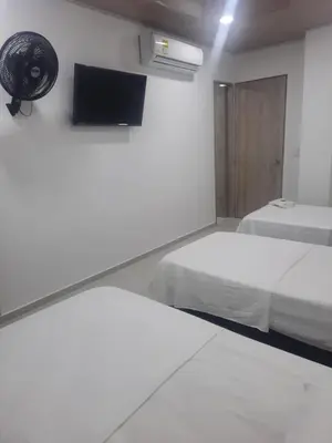 a room with two beds and a tv on the wall at HOTEL MAR DEL CARIBE in Soledad