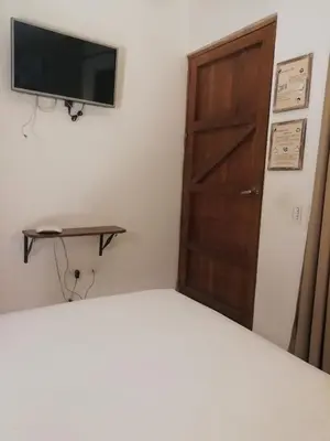 a bedroom with a bed with a television and a door at Casa Ebano 967 in Cartagena de Indias