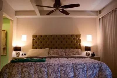 a bedroom with a large bed with a ceiling fan at Casa Ebano 967 in Cartagena de Indias