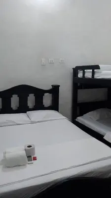 a bedroom with two beds with white sheets at Hostal #10-33 in Cartagena de Indias