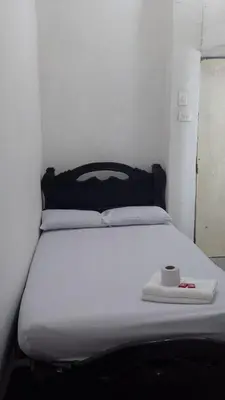 a white bed with a cup on top of it at Hostal #10-33 in Cartagena de Indias