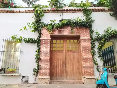 a moped parked in front of a house with a wooden door at Casa Ego in Cartagena de Indias