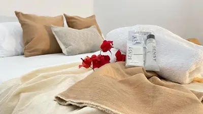 a white bed with red flowers on top of it at Casa Ego in Cartagena de Indias