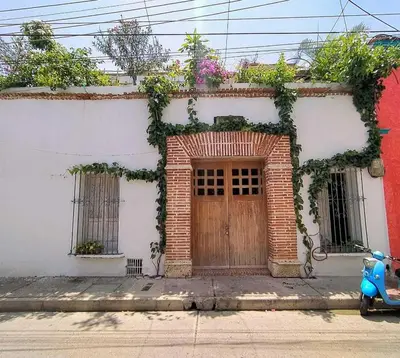 a moped parked in front of a house with a door at Casa Ego in Cartagena de Indias