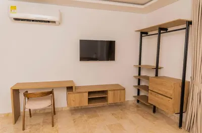 a room with a desk and a tv on a wall at Del Mar Guest House in Cartagena de Indias
