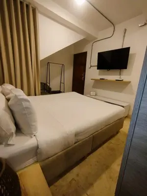 a bedroom with a bed and a flat screen tv at Del Mar Guest House in Cartagena de Indias