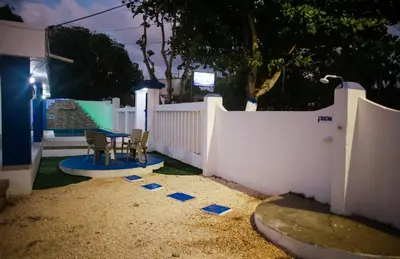 a backyard with a white fence and two chairs and a table at Cabaña Perla Azul in Coveñas