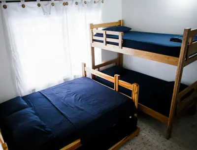 a bedroom with two bunk beds and a window at Cabaña Perla Azul in Coveñas