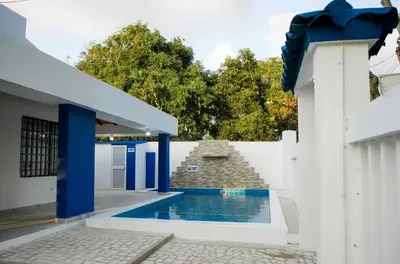 a house with a swimming pool next to a white fence at Cabaña Perla Azul in Coveñas