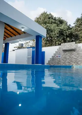 a swimming pool with blue columns in a house at Cabaña Perla Azul in Coveñas
