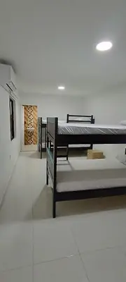 two beds sitting in a room with a white floor at Casa Para 3 a 12 personas in Cartagena de Indias