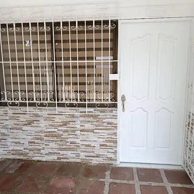 a white door in front of a brick wall at Casa Para 3 a 12 personas in Cartagena de Indias