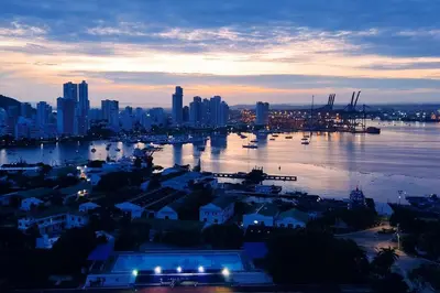 a view of a city with a harbor at dusk at Lujoso apartamento Boca grande Condominio H2 in Cartagena de Indias