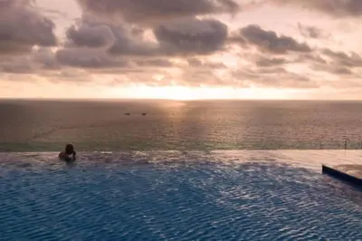 a person sitting in a swimming pool overlooking the ocean at Lujoso apartamento Boca grande Condominio H2 in Cartagena de Indias