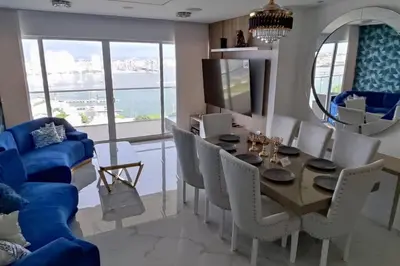 a dining room with a blue couch and a table and chairs at Lujoso apartamento Boca grande Condominio H2 in Cartagena de Indias