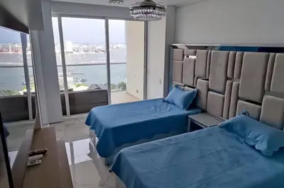 a room with two beds and a large window at Lujoso apartamento Boca grande Condominio H2 in Cartagena de Indias