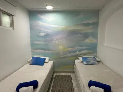 two beds in a room with a mural on the wall at Casa Cielo Cartagena in Cartagena de Indias